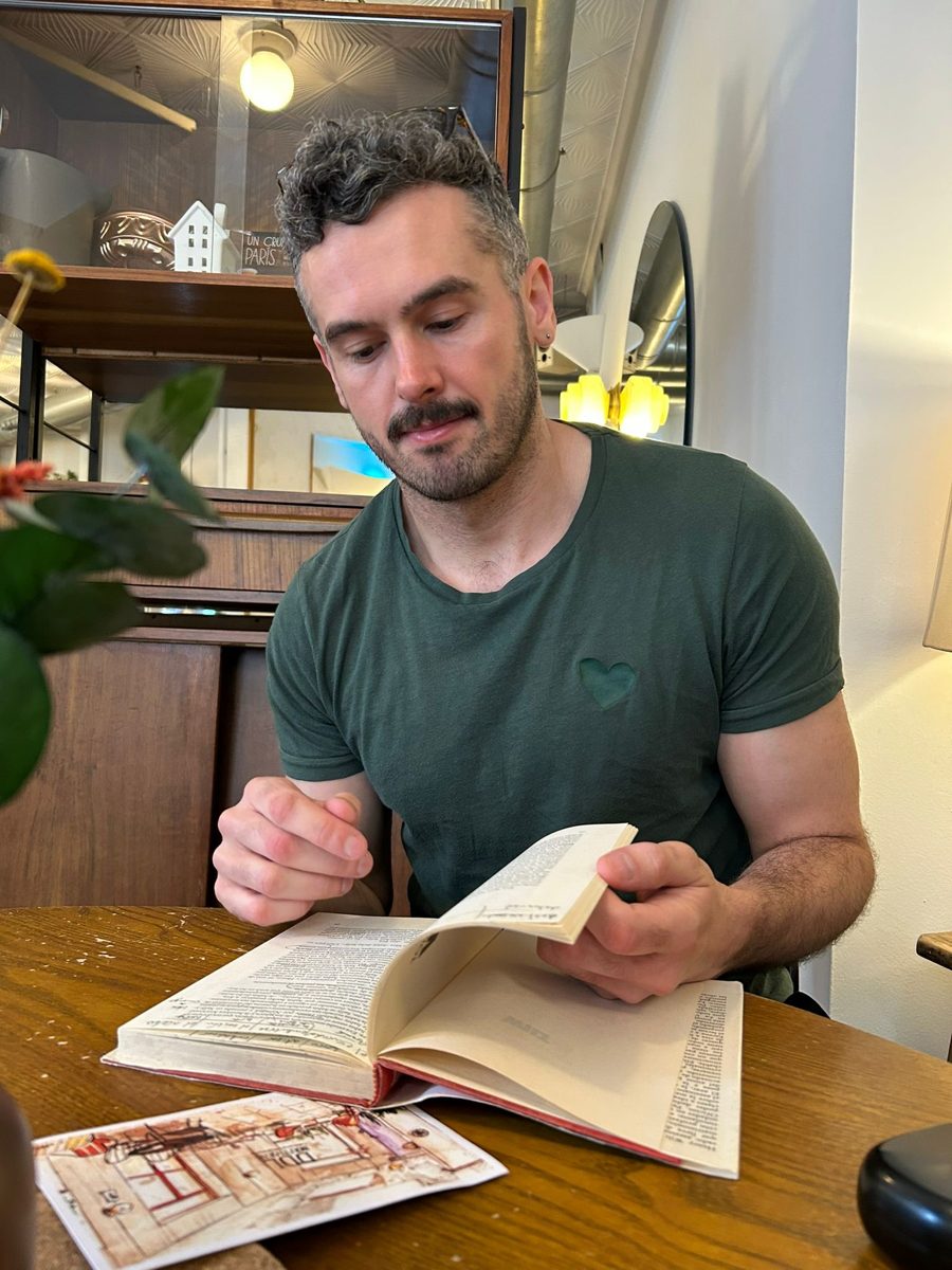 Oliver, known as El Inglés, reading at a café table